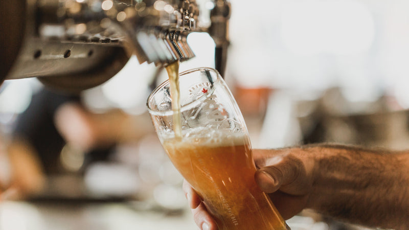 Person pouring chai beer from a tap into a glass